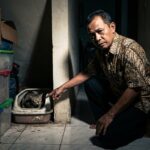Ilustrasi penempatan kotak pasir kucing yang salah di sudut sempit yang memicu stres pada kucing indoor.